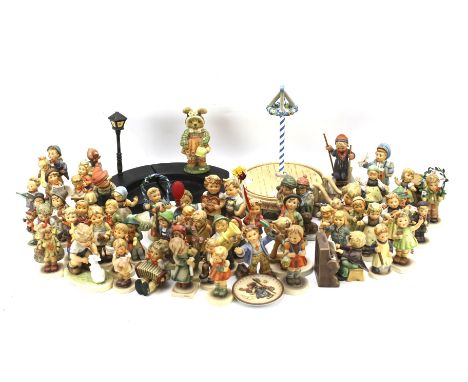 A large collection of Goebel Hummel figures of children, a May Pole and a wooden podest.