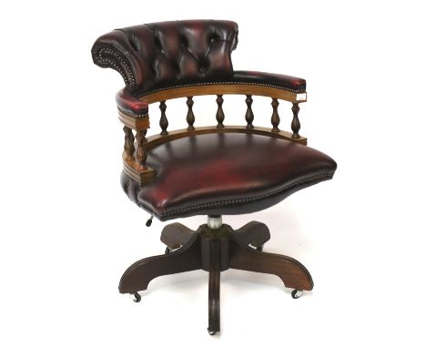 A contemporary captain's chair. Upholstered in red with button back, height 86cm
