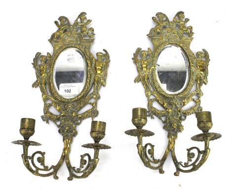 A pair of early 20th century brass two-light wall sconces with mirrored backs. L35cm