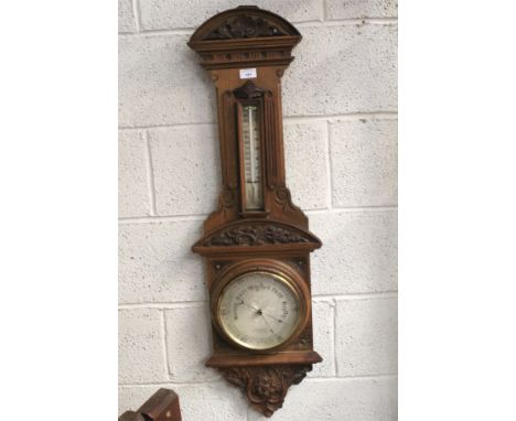 An early 20th century stained wooden wall barometer. The silvered dial marked 'Van Neck &amp; Co, Opticians, Buckingham Gate 