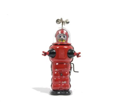 A Yoshiya K.O (Japan) Crank Driven Moon Explorer, red tinplate body, black feet and arms, clear plastic helmet with ray count