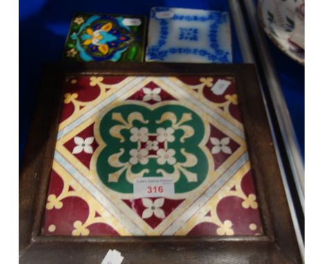 A VICTORIAN MINTON HOLLINS &amp; CO TILE, in a period oak frame, as a teapot stand and two smaller tiles (3)