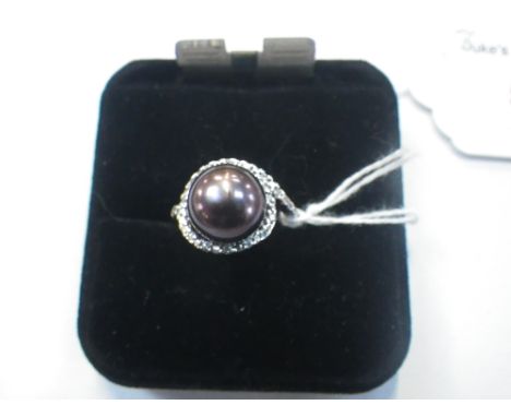 A BLACK SIMULATED PEARL DRESS RING, the pearl with green / mauve hues, on a silver shank, ring size M