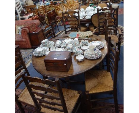 A SET OF SEVEN LADDER BACK CHAIRS with rush seats, to include two carvers