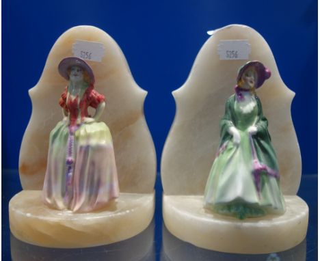 A PAIR OF 1930S ALABASTER BOOKENDS with ceramic ladies in period costume
