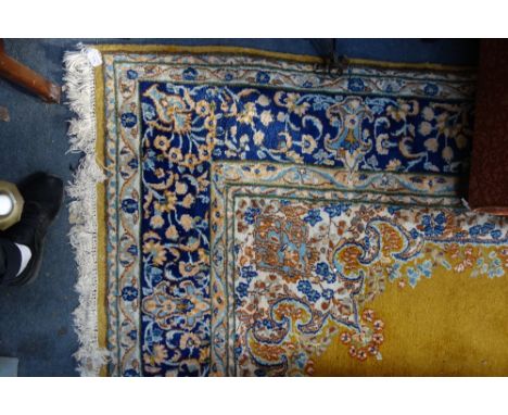 A MUSTARD GROUND ENGLISH CARPET, with a cream and blue floral border, 220cm wide x 310cm long (plus fringes)