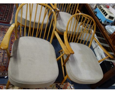 ERCOL; A NEAR PAIR OF PALE BEECH STICK BACK ARMCHAIRS with grey seat cushions