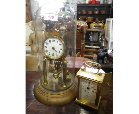 AN ANNIVERSARY CLOCK UNDER A GLASS DOME and a brass carriage clock