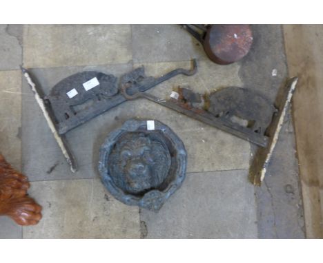 Two cast iron handing brackets and a metal lion door knocker 