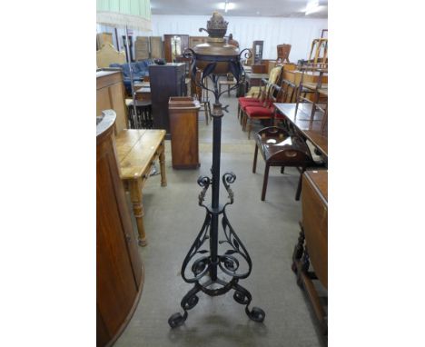 A Victorian Aesthetic Movement wrought iron and copper floor standing oil lamp 