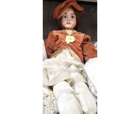 A bisque head doll with set brown eyes, open mouth with four teeth and jointed body, 70cm. 