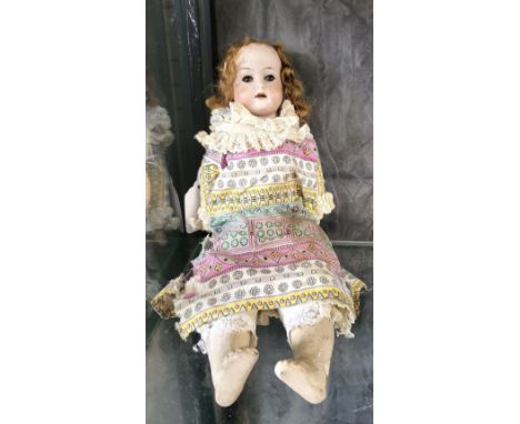A Heubach Kopplesdorf 250 .6 bisque head doll with slepping brown eyes, open mouth with four teeth and jointed composition bo