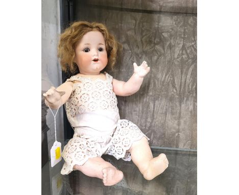 An Armand Marseille 351/4 bisque head baby doll with sleeping brown eyes, open mouth with two teeth and jointed cloth body, 4