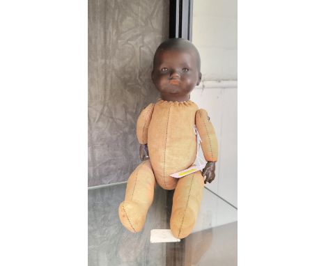 An Armand Marseille bisque head black body baby doll with sleeping brown eyes and jointed cloth body, 32cm. 