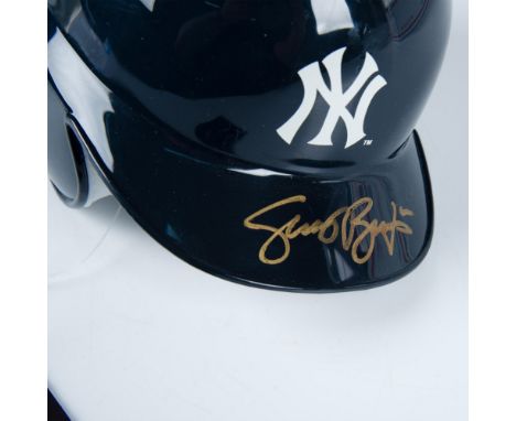 This is a miniature of an official MLB batting helmet with New York Yankees logo on the front and signed in gold by Scott Bro