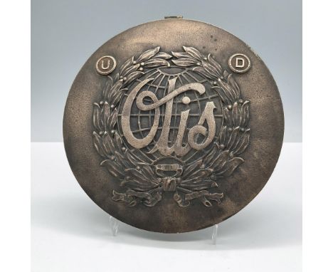 Showcases intricate details, including laurel leaves, a globe, and a prominent central monogram or insignia. Marked on the ba