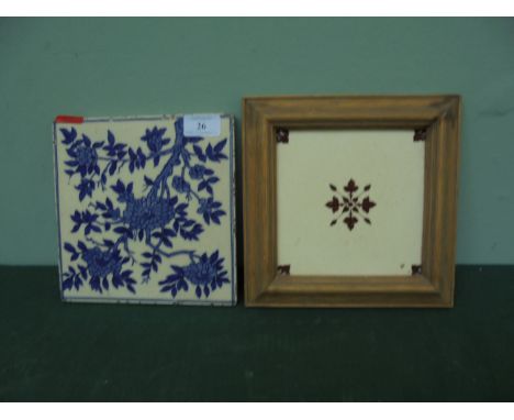 Framed brown and cream late Victorian wall tile and another blue and white patterned tile of similar vintage 