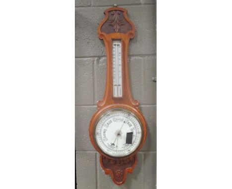 An Edwardian carved oak aneroid barometer