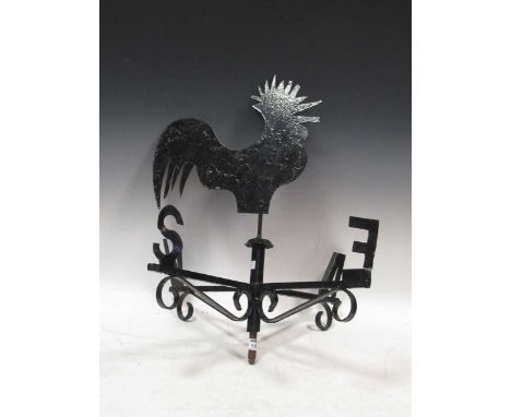 A black painted metal weather vane surmounted by a cockerel