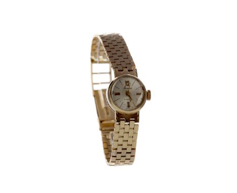 LADY'S NINE CARAT GOLD ACCURIST MANUAL WIND WRIST WATCH, the round cream dial with baton hour markers, applied baton and Arab