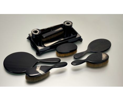 An Edwardian ebony London silver mounted ten-piece dressing table set to include, two hand mirrors, a pair of spill vases, a 
