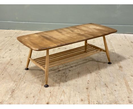An Ercol 1960s oak rectangular coffee table with rounded angles on beech turned splay supports with slatted under tier: h. x 