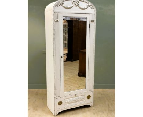 A continental wardrobe, with an arched top decorated with a swag, the mirrored door flanked by columns above a base with a si