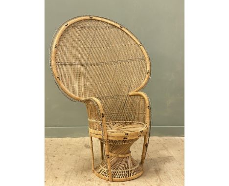 A vintage bamboo and rattan peacock chair with arched back with period black and white plastic alternating fringe on spiralin