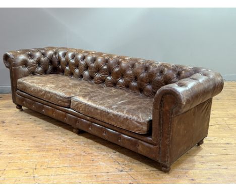 An American Restoration Hardware brown hide distressed finish three seater Chesterfield sofa with button back, on turned wood