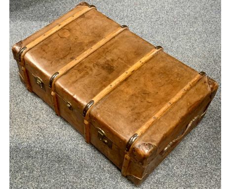 A LEATHER STEAMER TRUNK – early 20th century clad with bentwood bands, brass locks and clasps with satin lined interior, mono