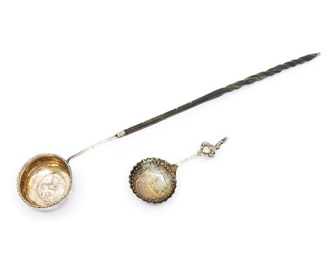 An 18th Century silver circular ladle the case inset with a Queen Anne 1707 shilling, with twisted handle, apparently unmarke