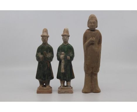 Three Chinese pottery funerary figures, Han Dynasty, including a pair of standing attendants in long robes, one holding a flu