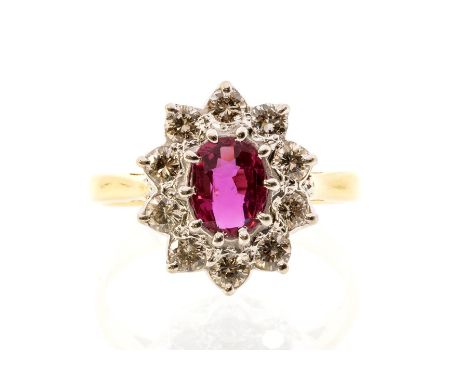 A ruby and diamond 18ct gold cluster ring, the oval ruby claw set to the centre weighing approx. 0.80ct, within a border of b