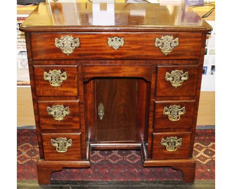 A George II mahogany kneehole desk, circa 1750, fitted with a single drawer to top, a secret frieze drawer below, with three 
