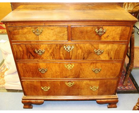 A George I walnut chest of drawers, circa 1720, projected moulded top, fitted with two short over three drawers, raised on br