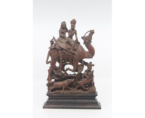 An Indian carved hardwood figure group of a hunting party, 19th Century, modelled as a dignitary and consort riding a camel w