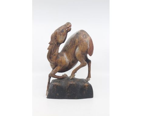 A Chinese carved softwood figure of a horse, possibly Ming Dynasty, modelled in a dramatic pose with head turned back, steppi