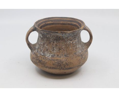 A Chinese painted pottery jar, Neolithic, of bellied form with twin strap handles, painted in black with bands and geometric 