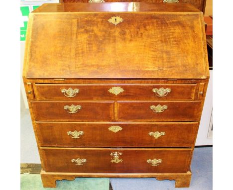 A George I and later walnut bureau, circa 1720, the fall front enclosing drawers, a central door, pigeon holes and a secret d