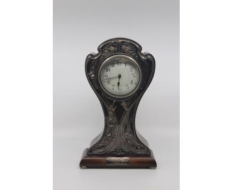 An Edwardian silver mounted mahogany cased mantle clock, Birmingham 1909,of waisted form, the silver embossed in the Art Nouv
