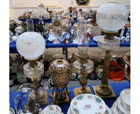 A brass column oil lamp with glass font, two other oil lamps, a part lamp etc Condition Report: Font cracked to main lamp.