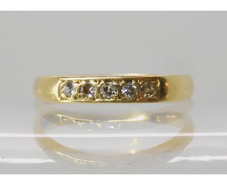 An 18ct gold five diamond band ring, size O1/2, weight 2.7gms Condition Report: Available upon request