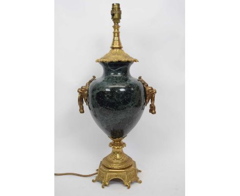 Lamp with gilt scrolling design to base to lion mask handles and onyx reservoir with gilt lamp fitting above, 55cm high