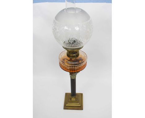 Oil lamp with white glass shade and amber glass reservoir above a Corinthian column, the lamp 50cm high