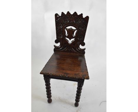 Victorian oak Gothic carved hall chair with pierced shield decorated back, raised on bobbin turned legs, 90cm high