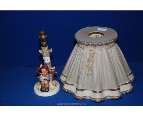A Hummel table lamp of Little boy holding a daisy sat by a stile, approx. 15" tall with shade.