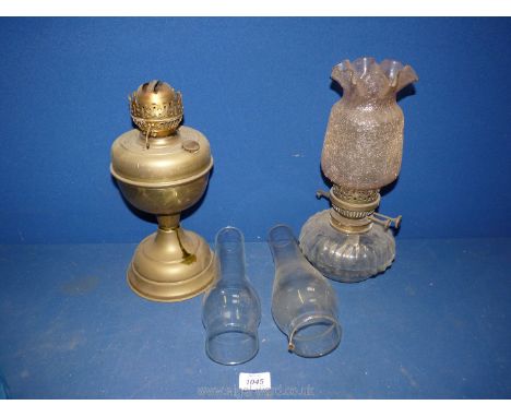 A Brass Oil Lamp with chimney, a glass based oil lamp with pink crackle glass shade and two spare glass chimneys.