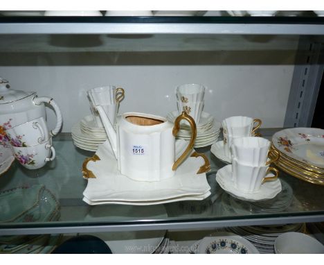 A part Wedgwood Tea Service in fluted white with gold handles and the entwined initials of G.W.L, one cup with crack and no l