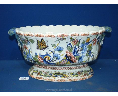 A large antique Rouen Faience wine cooler/planter with mask handles painted in polychrome with a cornucopia and butterfly.