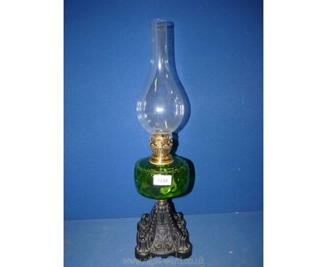 A Victorian oil lamp (working) with green reservoir and cast metal base, 21" tall. 
